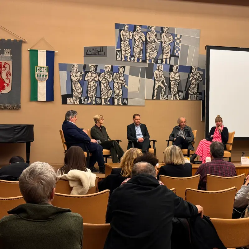 Foto: Zu sehen ist eine Podiumsdiskussion mit fünf Teilnehmenden.