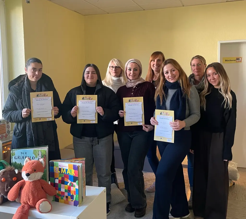 Foto: Mehrere Personen stehen nebeneinander und halten Urkunden in den Händen.