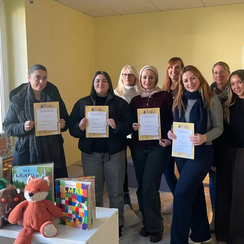 Foto: Mehrere Personen stehen nebeneinander und halten Urkunden in den Händen.