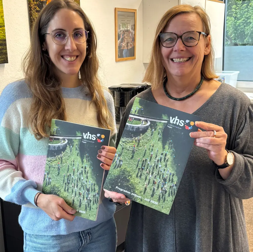 (v.l.) Sara Becker und Birgit Andrich aus dem Team der VHS halten jeweils ein neues Programmheft in den Händen.