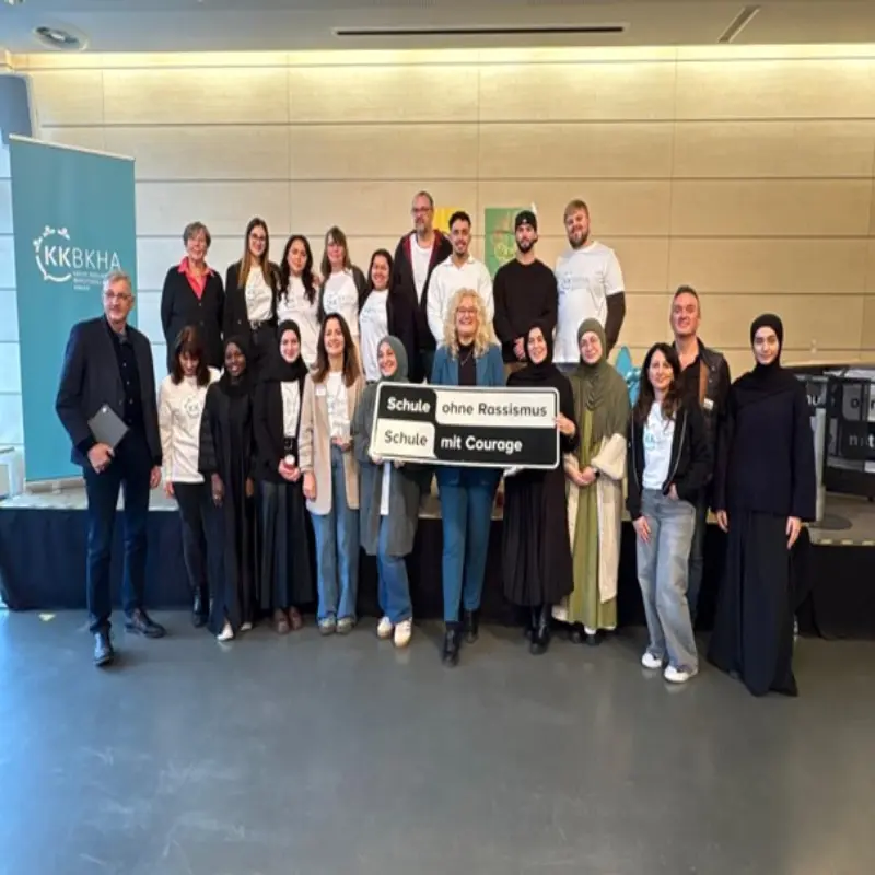 Foto: Gruppenfoto vieler Sch&uuml;lerinnen und Sch&uuml;ler, die ein Schild mit der Aufschrift &bdquo;Schule ohne Rassismus &ndash; Schule mit Courage&ldquo; pr&auml;sentieren.