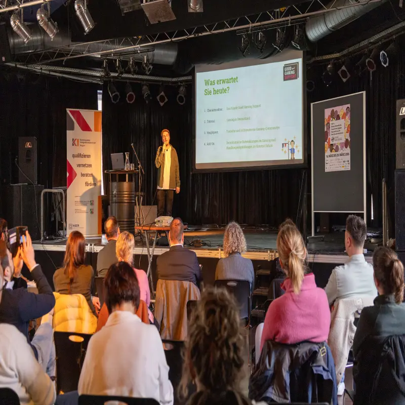 Foto: Sozialwissenschaftler Mick Prinz h&auml;lt eine Keynote auf der B&uuml;hne vor sitzendem Publikum.