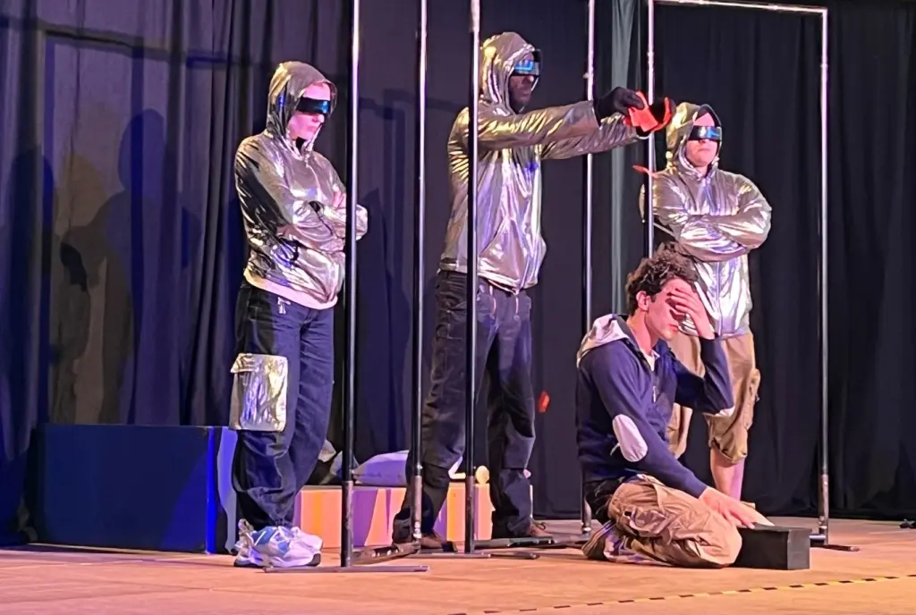 Foto: Vier Figuren des Theaterst&uuml;cks spielen eine Szene auf der B&uuml;hne.
