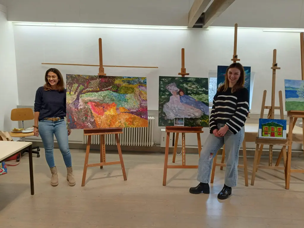Foto: Zwei Frauen pr&auml;sentieren zwei Gem&auml;lde.