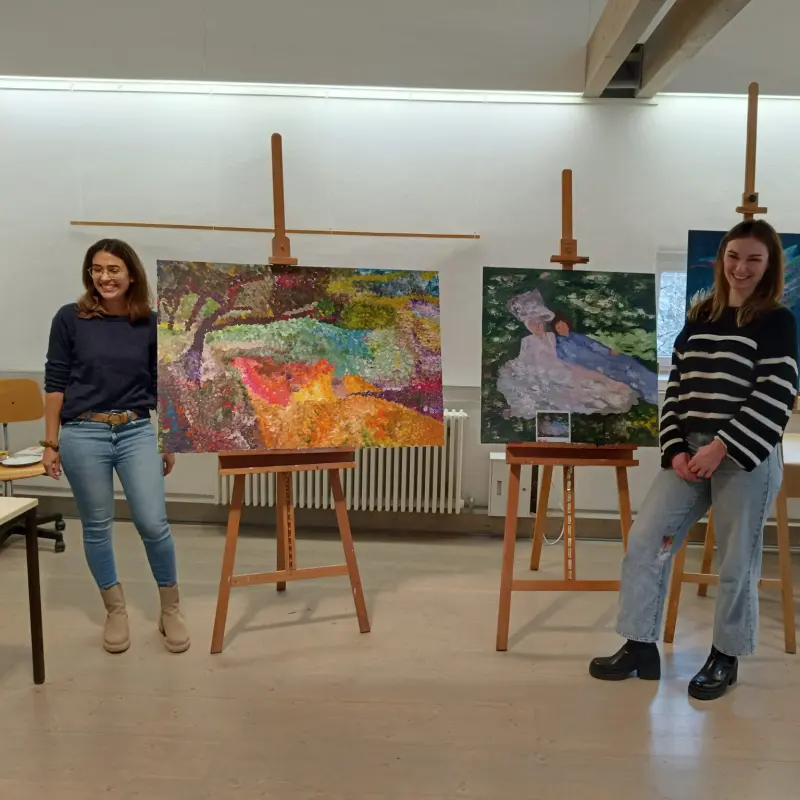Foto: Zwei Frauen pr&auml;sentieren zwei Gem&auml;lde.