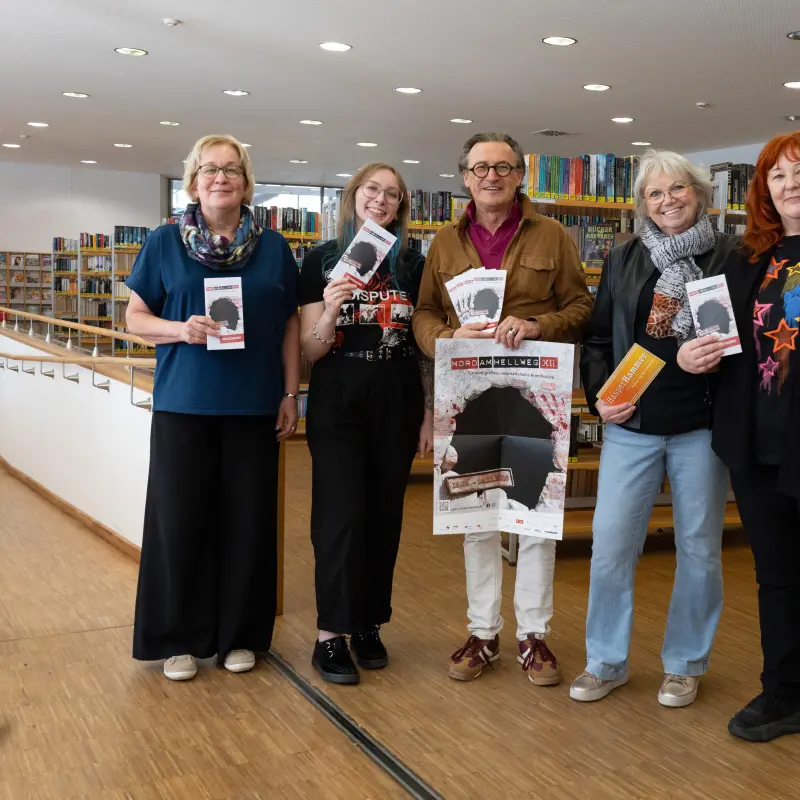 Foto: Die oben genannten Personen stehen nebeneinander und halten ein Plakat sowie Flyer in den Händen.