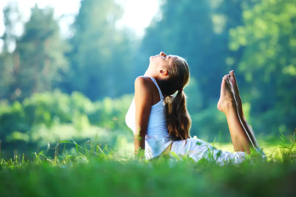 Foto: Eine Frau macht eine Yoga-Übung in der Natur