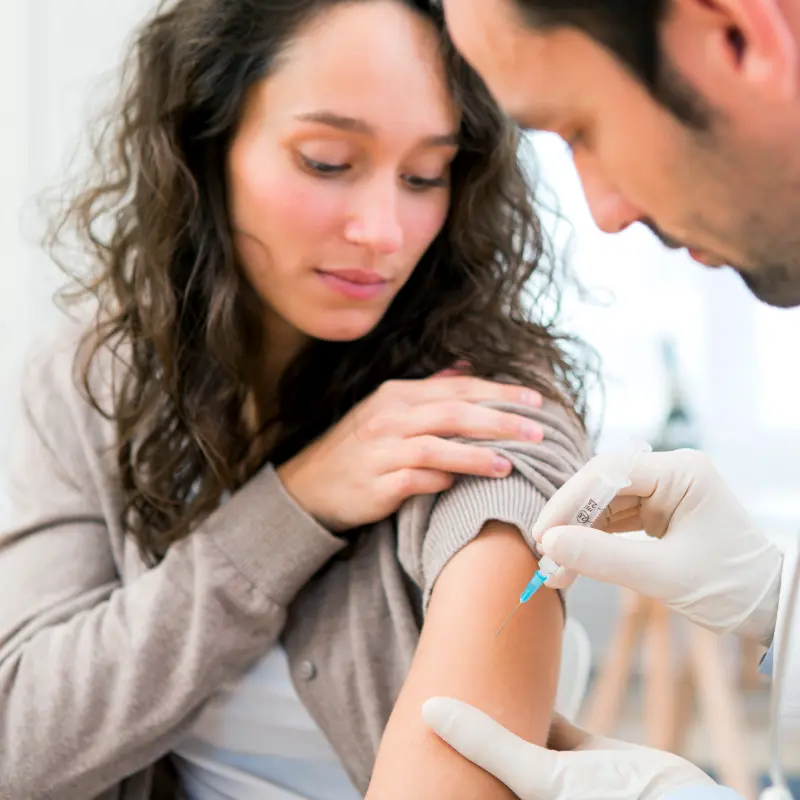 Foto: Symbolbild eines Arztes, der eine Patientin impft.