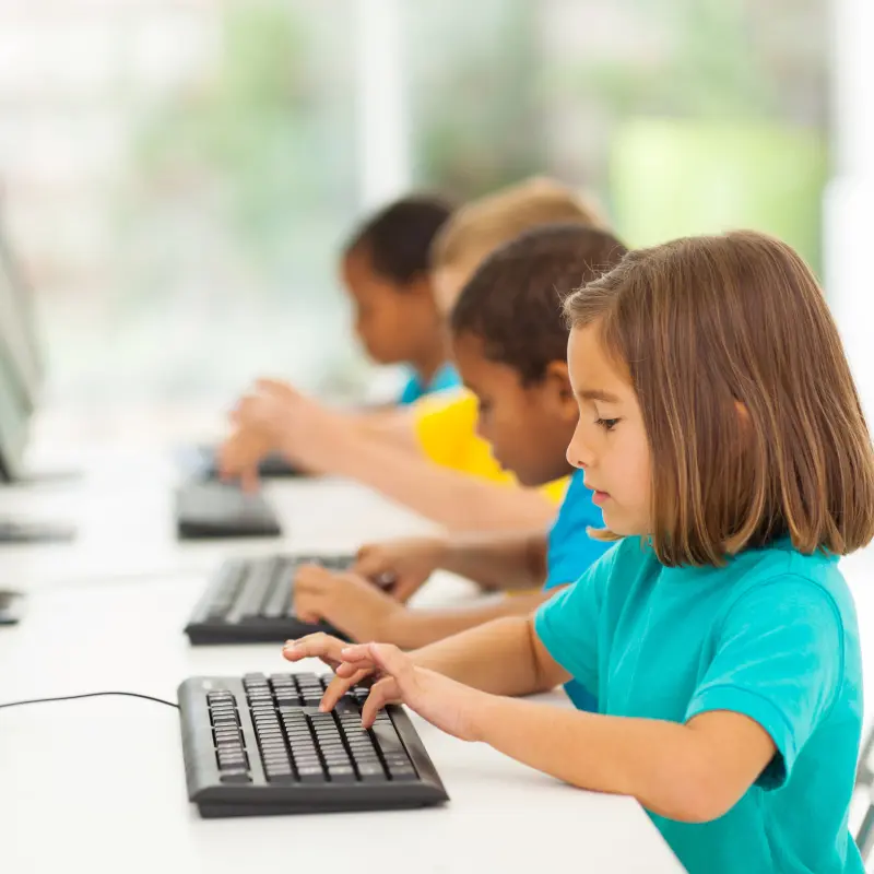 Symbolfoto: Mehrere Kinder sitzen vor Computerbildschirmen.