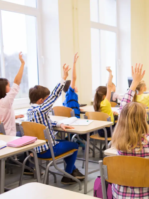Symbolbild: Klassenzimmer und Schülerinnen und Schülern sowie einer Lehrerin.
