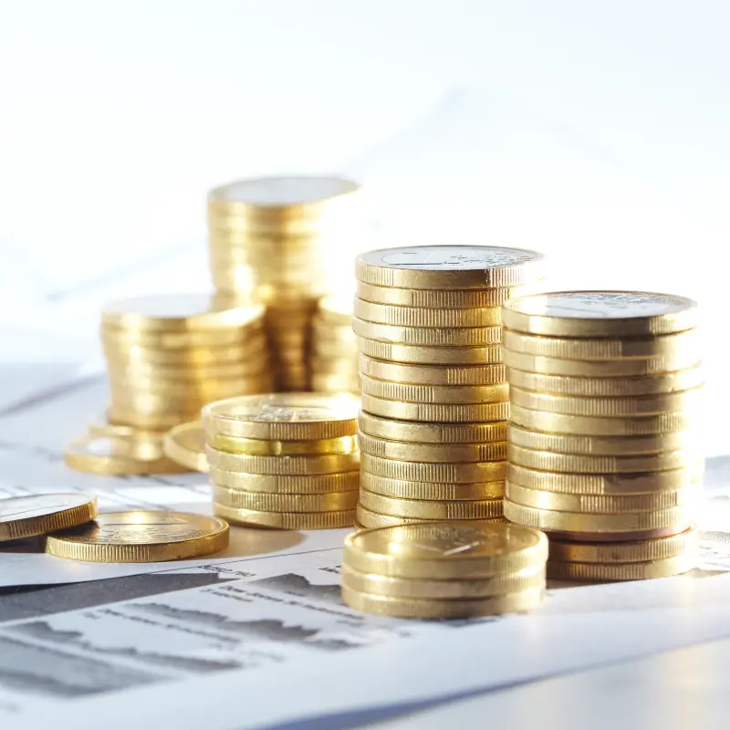 Symbolbild: Mehere Stapel Geldm&uuml;nzen stehen auf verschiedenen Formularen.