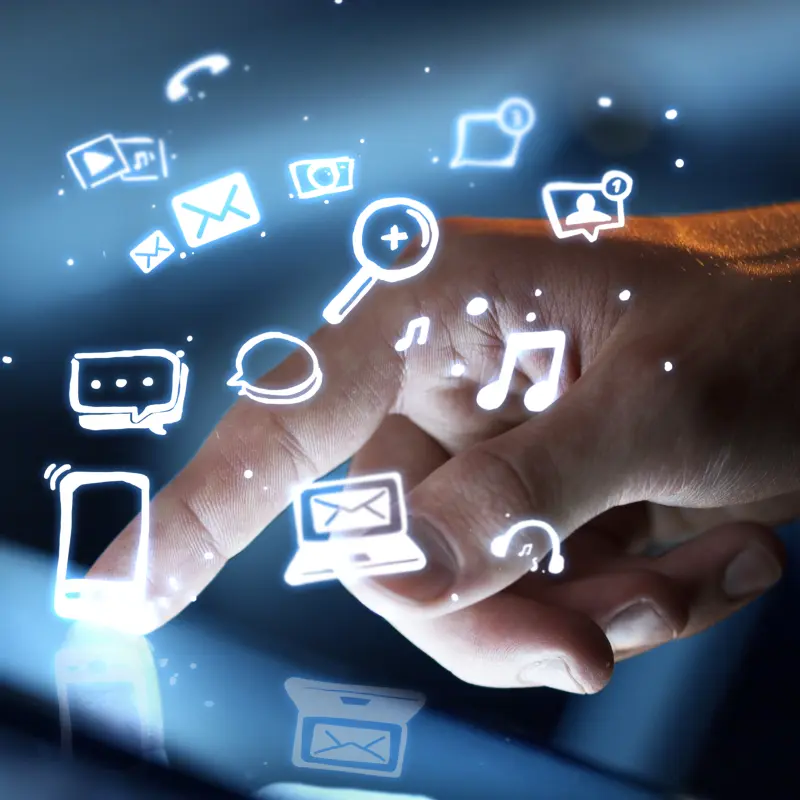 Foto: Symboldbild einer Hand die auf ein mobiles Ger&auml;t tippt. &Uuml;ber dem Ger&auml;t schweben imagin&auml;re Icons.