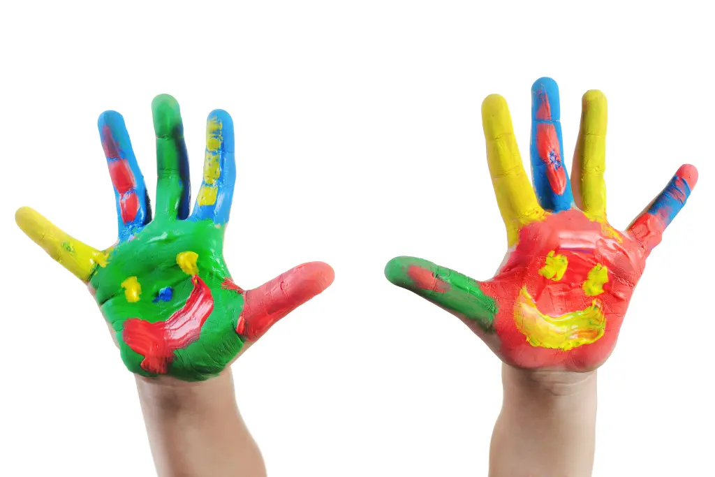 Foto: Zwei Kinderhände voller Handmalfarbe, auf die Handflächen ist jeweils ein Smiley gezeichnet.
