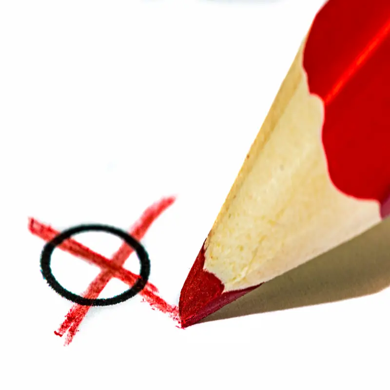 Foto: Ein roter Stift malt ein rotes Kreuz.