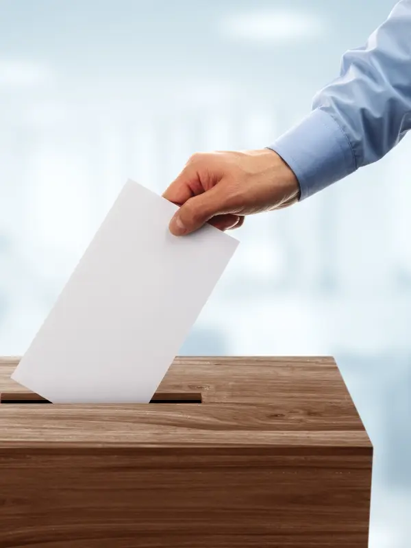 Foto: Ein Mann wirft einen Wahlbrief in eine Urne.