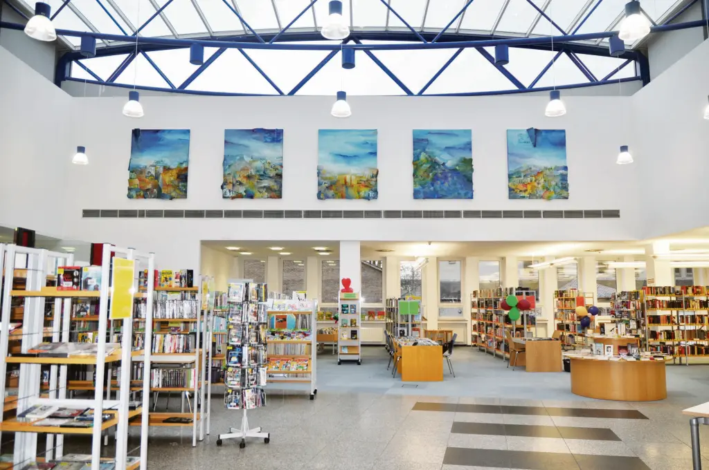 Foto: Hauptraum der Stadtteilbücherei Hohenlimburg mit einer hohen Decke und vielen Bücherregalen.
