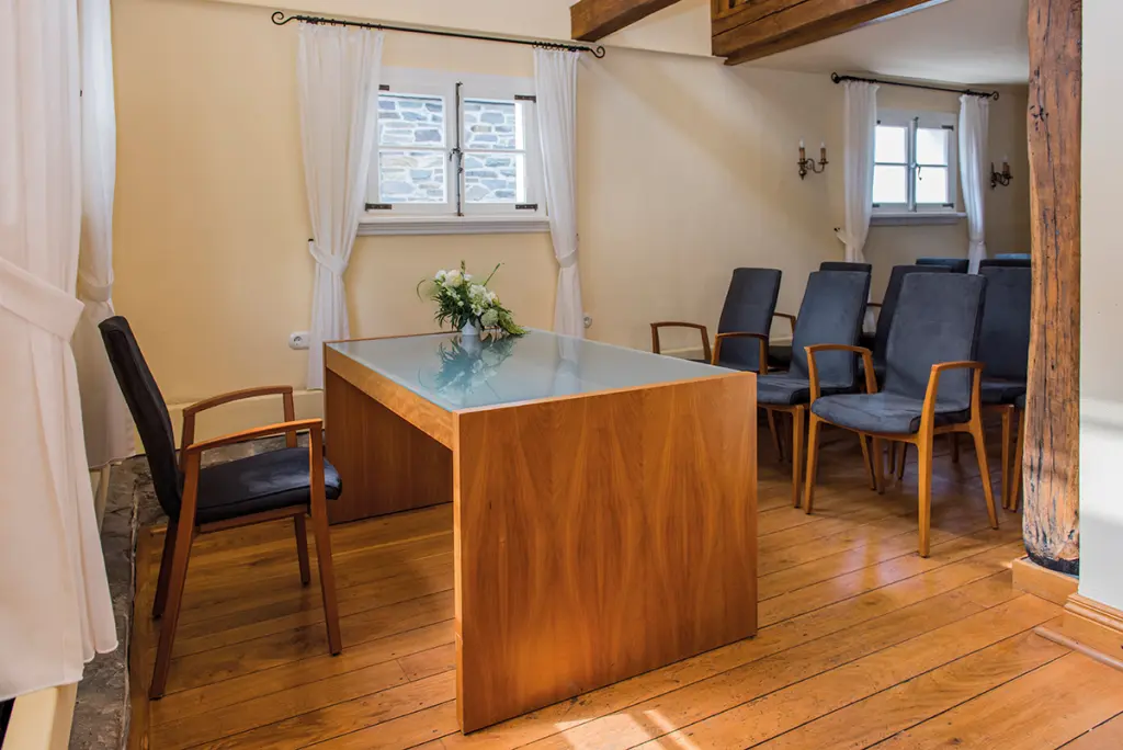 Foto: Ein Trauzimmer mit hellem Holzboden und einer schmalen Sitzreihe.