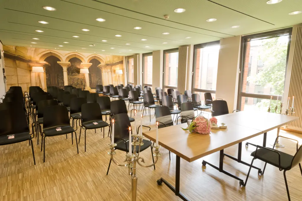 Foto: Ein großer Saal mit Fensterfront und mehreren Stuhlreihen.