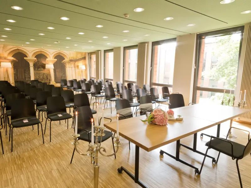 Foto: Ein großer Saal mit Fensterfront und mehreren Stuhlreihen.