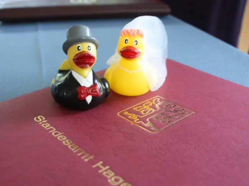 Foto: Zwei Quietscheenten in Hochzeitskleidung sitzen auf einer Eheurkunde der Stadt Hagen.