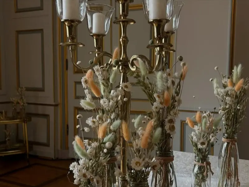 Foto: Mehrere Blumengedecke auf einem langen Tisch mit einer Tischdecke aus Samt.
