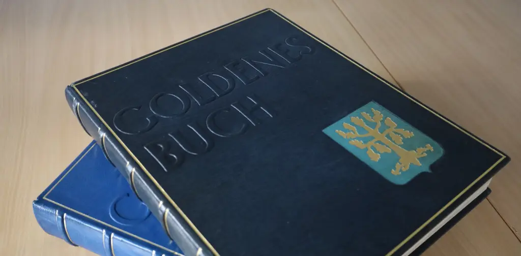 Foto: Die zwei goldenen Bücher der Stadt Hagen liegen auf einem Holztisch.