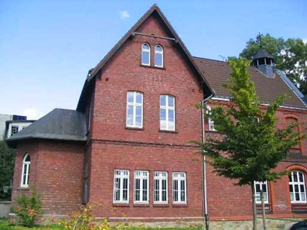 Foto: Die Fassade des Jugendzentrum Eckesey mit einem Apfelbaum im Garten.