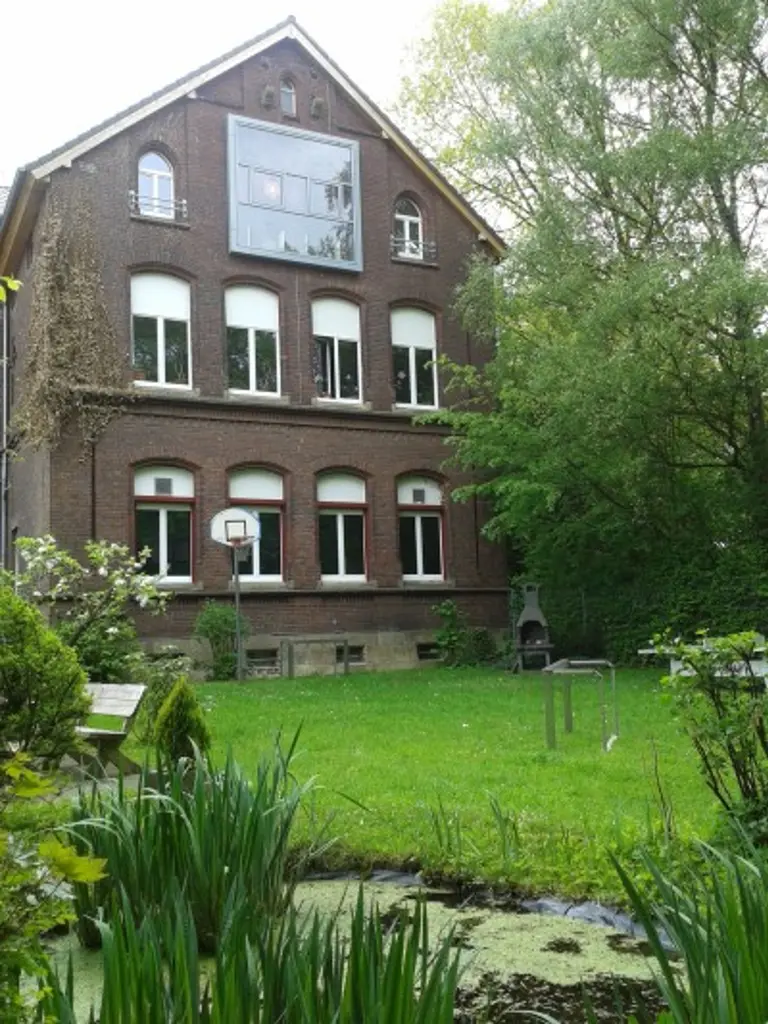 Foto: Das Gebäude des Kinder- und Jugendtreff Eilper Welle mit vielen Fenster und einem großen Garten.