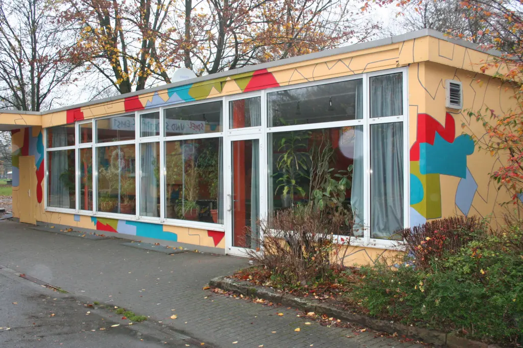 Foto: Das Gebäude des Spiel- und Sportpark Emst mit selbstgemachten Malereien auf der Fassade.
