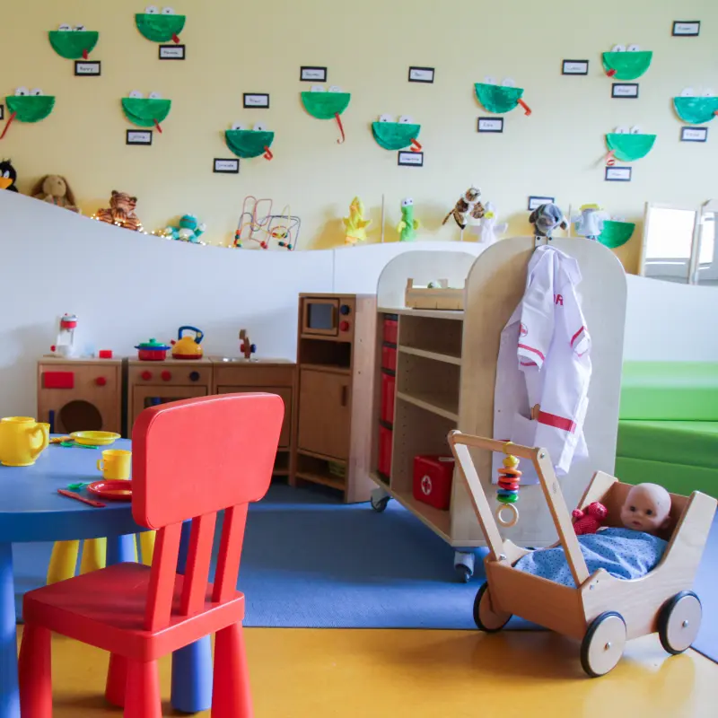 Foto: Spielraum in der Kita Eschwenweg mit bunten Kinderstühlen und Spielzeug.