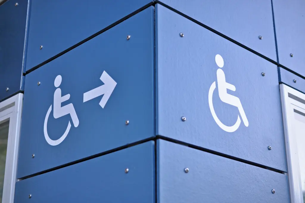 Foto: Eine Hauswand mit dem Symbol für Behindertenparkplätze.