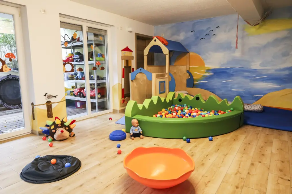 Foto: Der Innenraum einer Kindertagespflege mit einem Bällebad und einer Spielburg aus Holz.