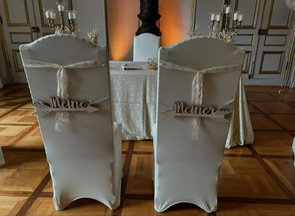 Foto: Zwei mit weißem Stoff überzogene Stühle mit der Aufschrift "Meiner" und "Meine"