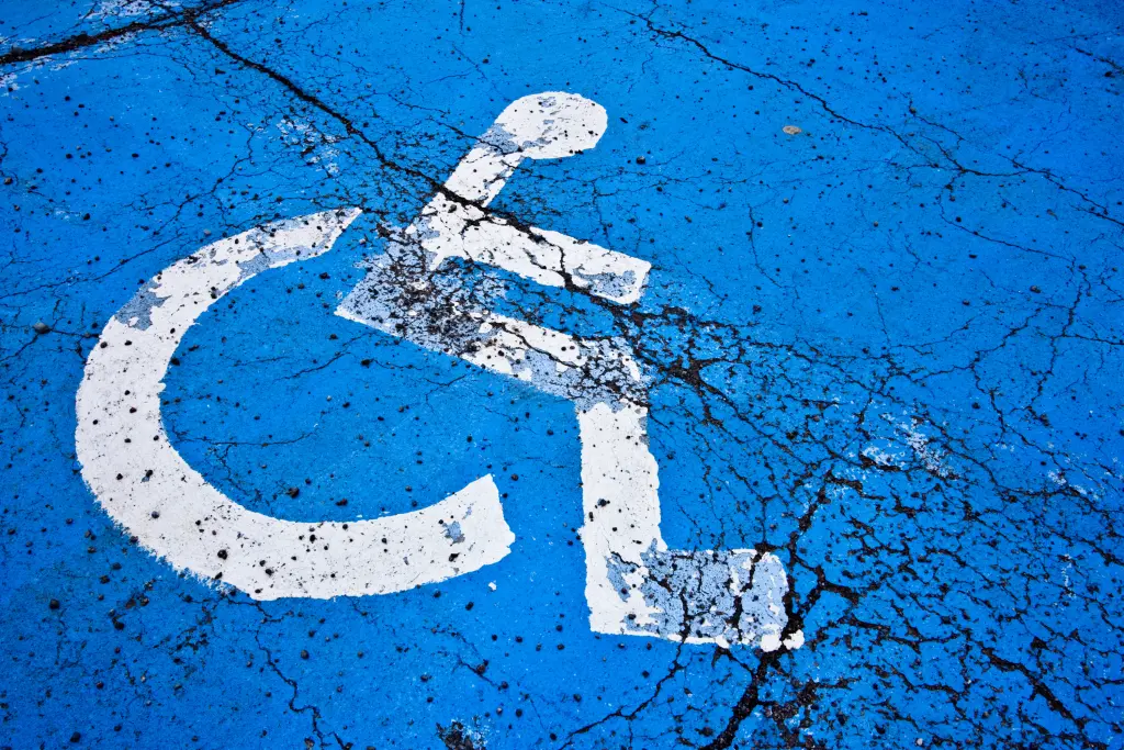 Foto: Eine Parkfläche, auf die das Symbol eines Behindertenparkplatzes gemalt ist.