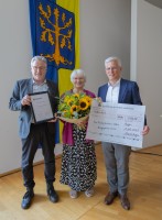 Renate Korthaus-Mobio erhält von Oberbürgermeister Erik O. Schulz (re.) und Dr. Josef Bücker, Vorsitzender des Ausschusses für Bürgeranregungen und Bürgerbeteiligung (li.), den Bürgerpreis 2024 der Stadt Hagen. (Foto: Karla Koball/Stadt Hagen)