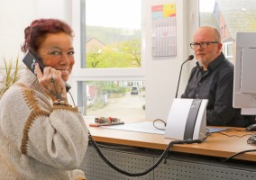 Corina Lemke (li.) ist hörgeschädigt und freut sich über das Theken-Ringschleifensystem am Arbeitsplatz von Stefan Schmitz (re.), stellvertretende Teamleitung im Bürgeramt Haspe. (Foto: Christof Becker)